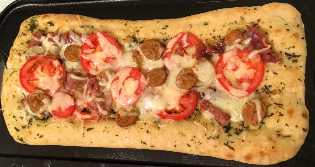 Fokachio Flat Bread Pizza with tomato, basil, garlic, prosciutto, italian sausage, mozzarella and olive oil